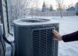 Hand holding heat pump outdoor unit data plate