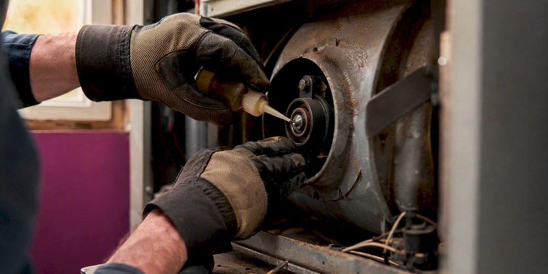 1787198682868_Hands-lubricating-blower-motor-bearing Hands lubricating blower motor bearing