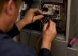 Technician testing HVAC control board voltage