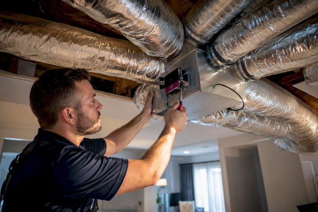 Technician adjusting HVAC zoning damper