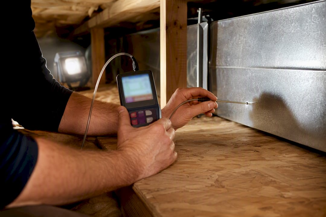 Technician measuring pressure at a return-air duct