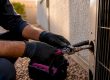 Technician disconnecting old AC equipment