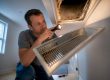 Homeowner inspecting suspected mold at air register