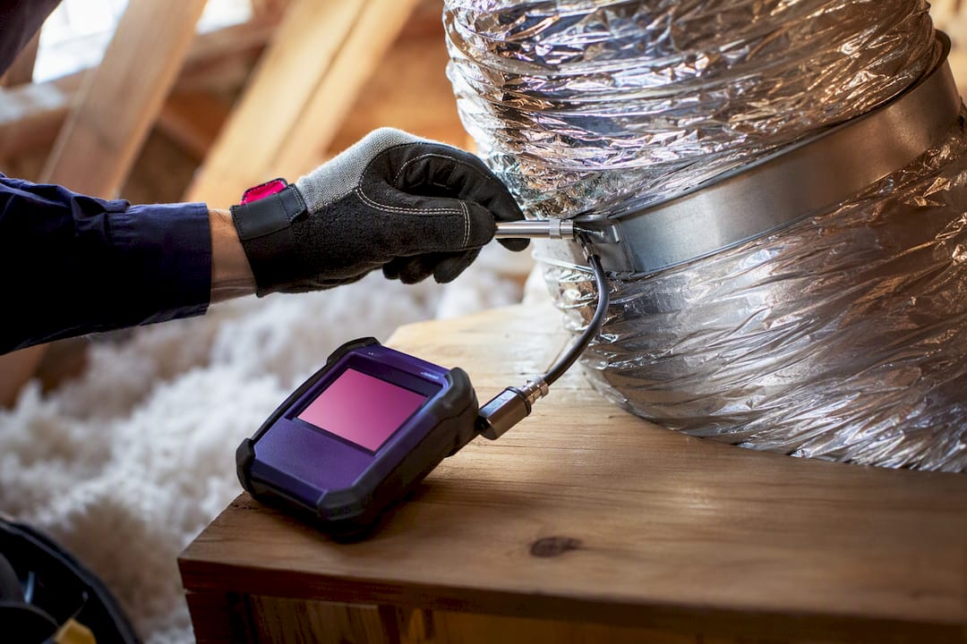 Technician testing leakage at duct connection