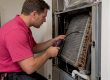 Technician checking an exposed evaporator coil