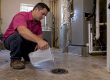 Homeowner refilling a mechanical-room floor drain