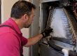 Technician inspecting an iced air conditioner coil