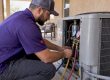 Technician checking an older residential AC condenser