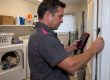 Technician checks pressure beside a running dryer