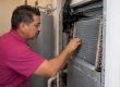 Technician inspecting an indoor evaporator coil